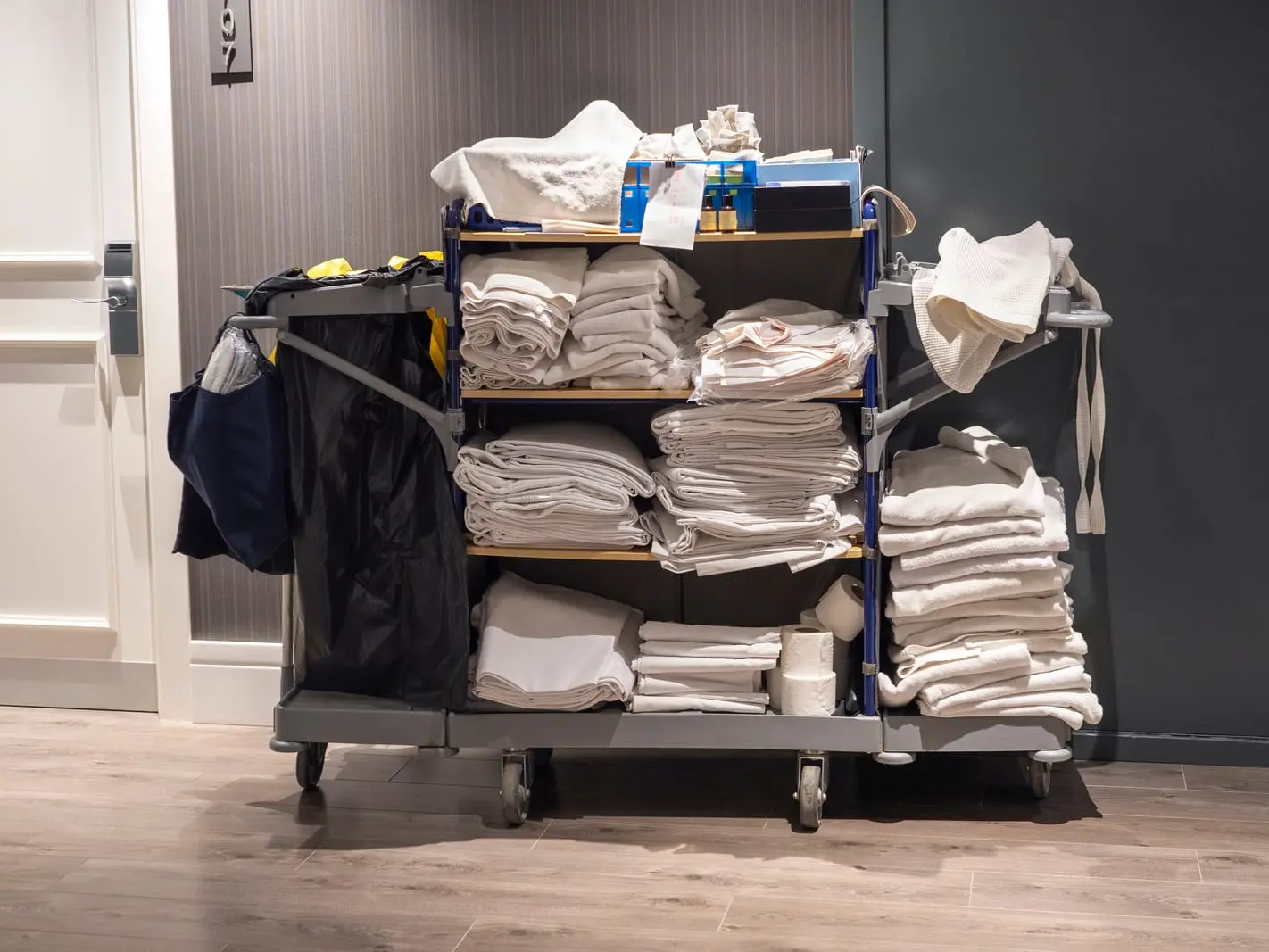 organized trolley with folded towels and miscellaneous items. A trolley with neatly folded towels and various items.